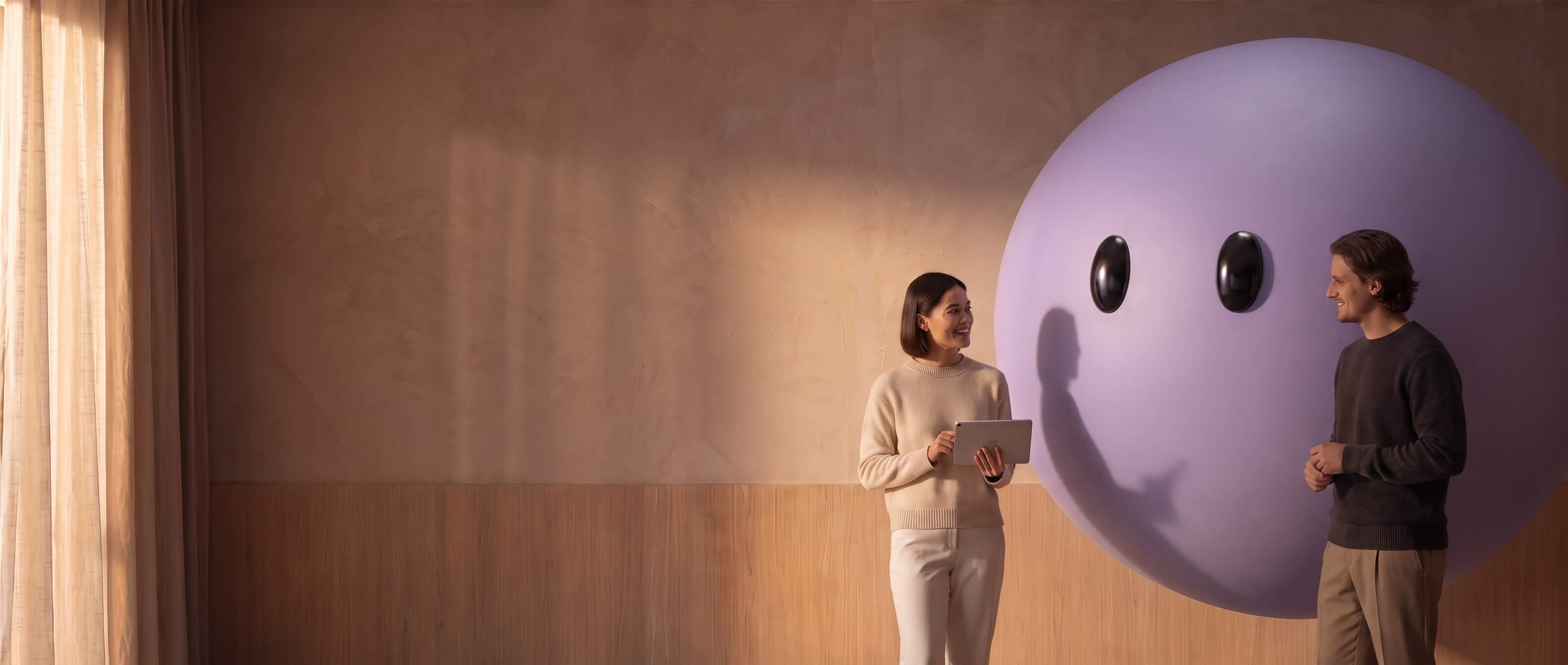 Two colleagues reviewing a tablet beside the purple Ayro mascot
